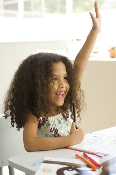 Girl raising hand in the classroom