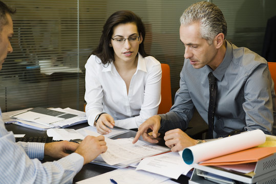 Clients discussing paperwork with businessman