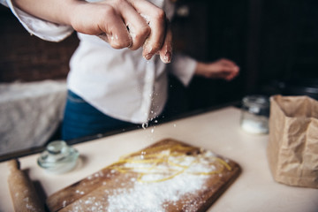 Obraz na płótnie Canvas A girl in the kitchen prepares a dough