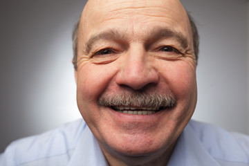 Elderly man laughs from ear to ear, giggles on the funny stories. Be happy of news or events