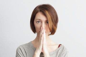 Timid and girl shyly looking ahead, palms together