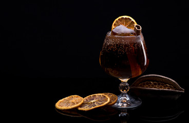 Cocktail with cola soda, ice, cinnamon and lemon
