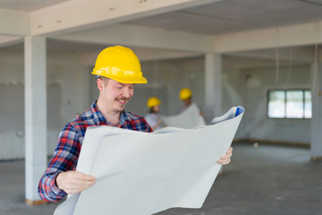 Engineer smart man looking and smilling at blue print portrait