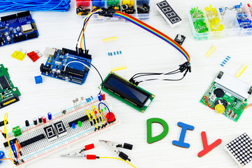 Microcontrollers, chips, resistors and light-emitting diodes on white desktop of hardware engineer....