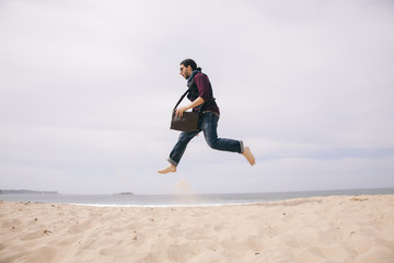funny young man jumping high on the sand