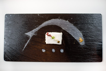 Close-up of a modern molecular dish in a plate isolated on a dark background