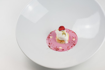Close-up of molecular dessert made of white cream and pink sauce