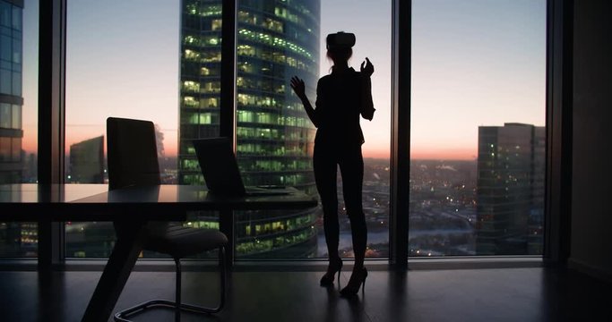 silhouette Technology VR-businessman young girl wearing virtual reality technology VR Glasses to work in modern office in a skyscraper. the creation of the presentation