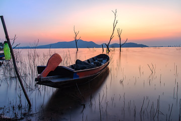 Fototapeta na wymiar Alone fishing boat at lake with sunrise