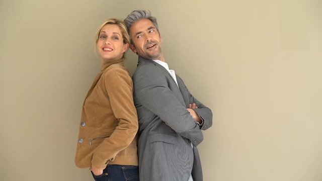 Middle-aged couple standing on grey background, isolated