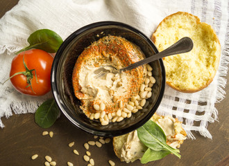 hummus appetizer with pine nuts on wooden table