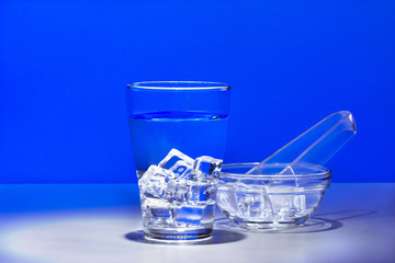 Вода и кубики льда в бокале и лёд в стеклянной чаше.