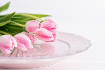 Obraz na płótnie Canvas Closeup of pink tulips on pink plate