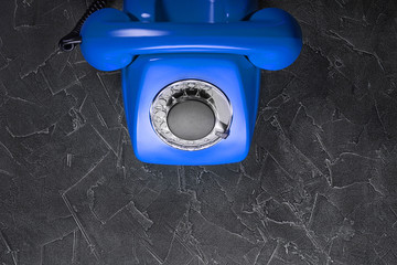 Fototapeta premium landline blue phone on a gray wall background