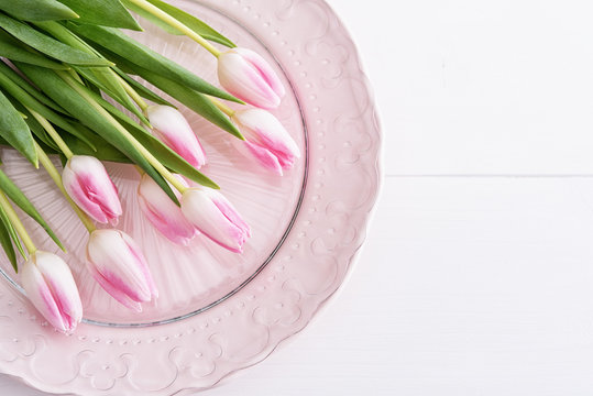 Top view on pink tulips on pink plate