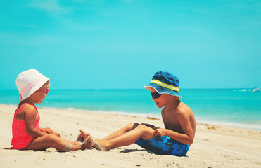little boy and girl having fun on beach