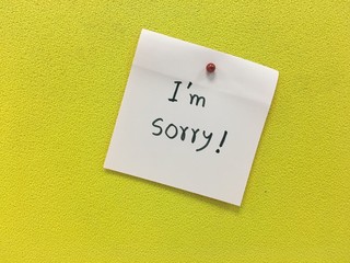 a handwritten notes with i am sorry message on yellow background.