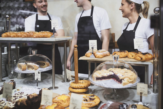 Men and woman working together at coffee and pastry shop and smiling.