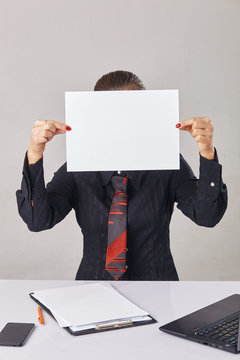 woman covering her face with a piece of paper
