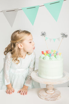 Girl blowing at birthday cake