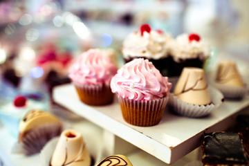 Tasty caramel cupcakes with pink cream on top