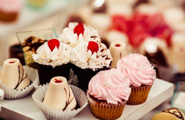 Chocolate cupcakes with white cream and berries on top