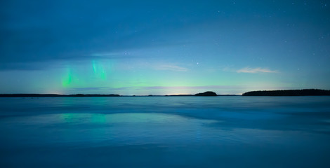Northern lights over calm lake (Aurora borealis) in Sweden