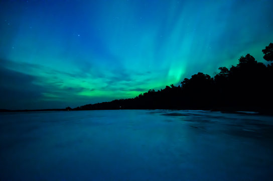 Northern lights over calm lake (Aurora borealis) in Sweden