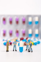 medical drug capsule and miniature people on white background,medical concept
