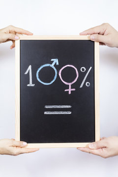 Hands of man and woman holding a blackboard with the symbol of gender equality
