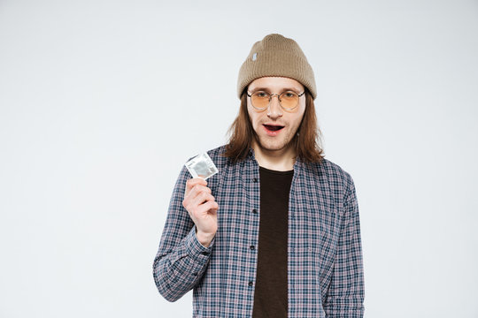 Young hipster holding condom