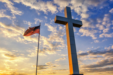 Cross and American flag at sunset