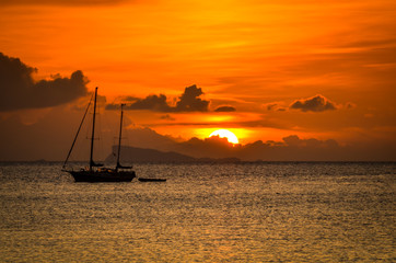 tropical sunset with silhouette of boat