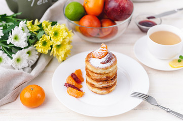 cheese pancake with citrus fruits and jam on a wooden table with tea. Breakfast concept