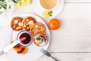 cheese pancake with citrus fruits and jam on a wooden table with tea. Breakfast concept