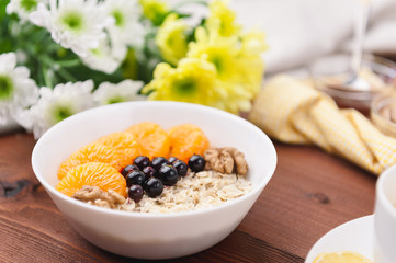 Oatmeal with fruit and berries on a wooden background.