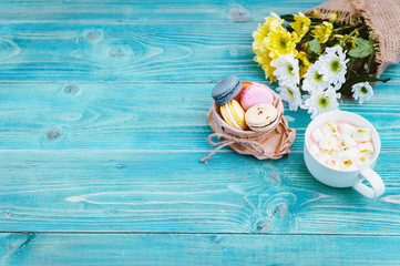 Macarons and mug with hot chocolate and marshmallows