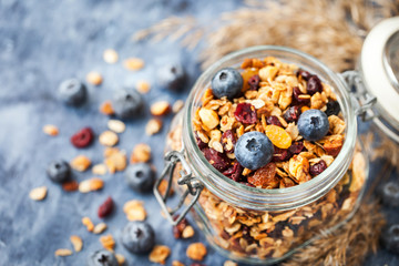 Homemade granola in jar and fresh blueberry