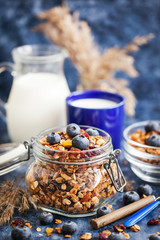 Homemade granola in jar, fresh blueberry and milk
