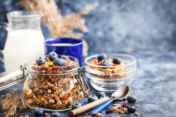 Homemade granola in jar, fresh blueberry and milk