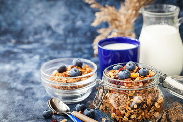 Homemade granola in jar, fresh blueberry and milk