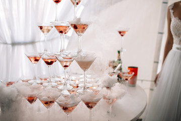 Champagne glasses. Wedding slide champagne for bride and groom. Colorful wedding glasses with champagne. Catering service. Catering bar for celebration. Beauty of bridal interior for wedding