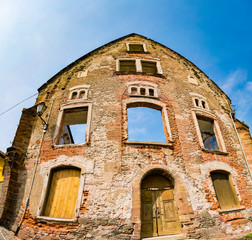 The facade of an old brick destroyed house