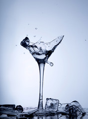 Water splash in a broken goblet. Water drops in a glass. Shattered goblet