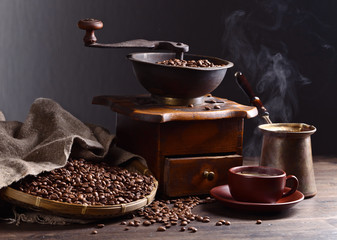 Cup of black coffee , coffee grinder and roasted beans