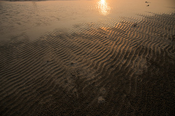 Water sunset reflect on sand beach