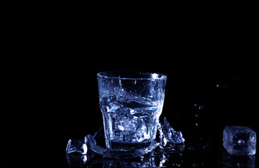 Water splash in a glass. A glass of cold water. Cold water with ice