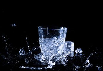 Water splash in a glass. A glass of cold water. Cold water with ice