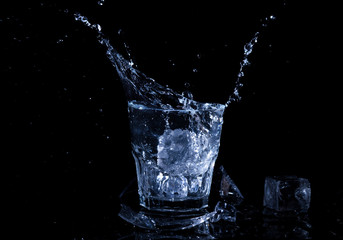 Water splash in a glass. A glass of cold water. Cold water with ice
