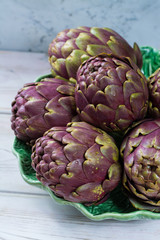 Obraz premium Fresh big Romanesco artichokes green-purple flower heads ready to cook